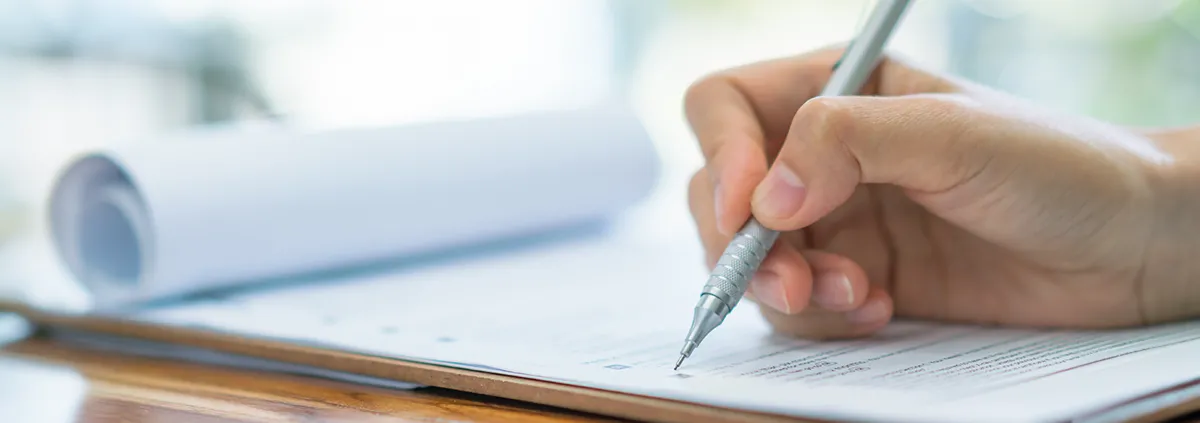 Image of a pen writing on white paper.