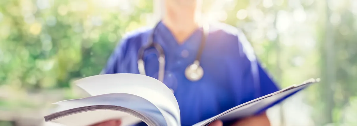 Healthcare worker looking at a book.