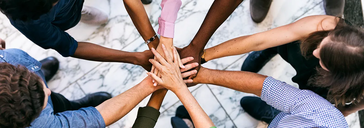 Team Of Diverse Workers Put Hands Together