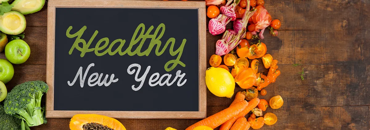 board surrounded by fruits and vegetables that says 'healthy new year'