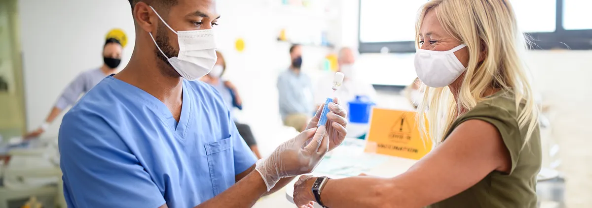 Medical professional administering vaccine to senior woman