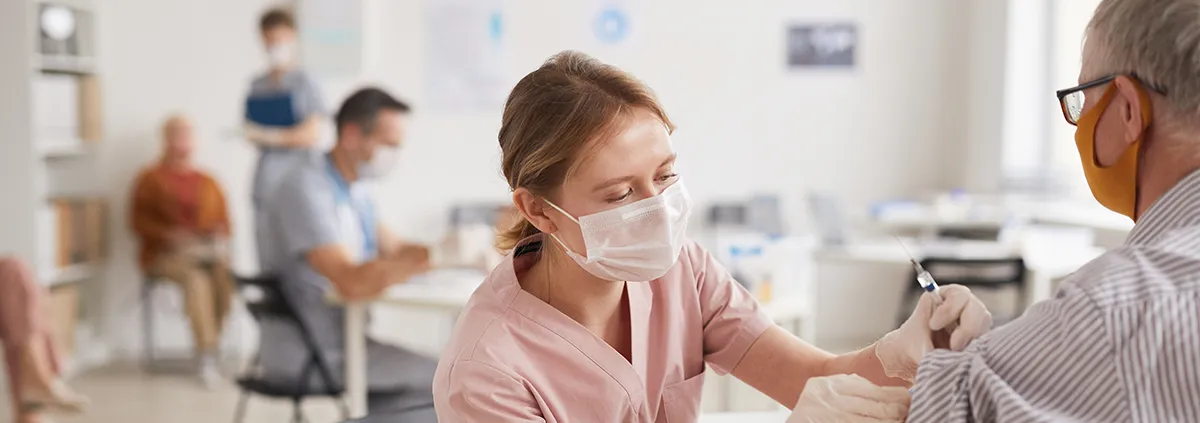 clinician giving elderly patient a shot