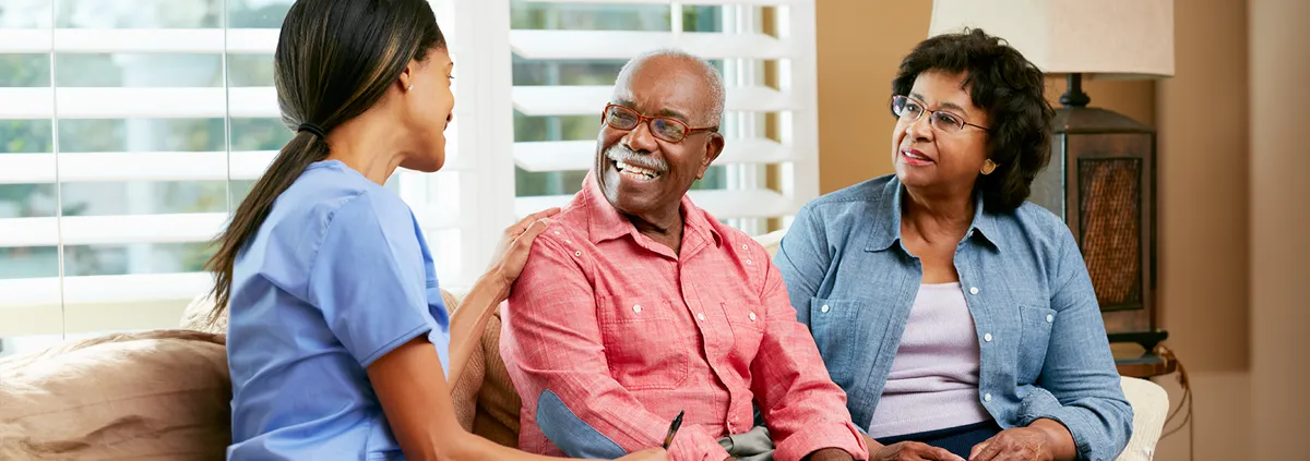 Clinician with patient and family sitting on a love seat 