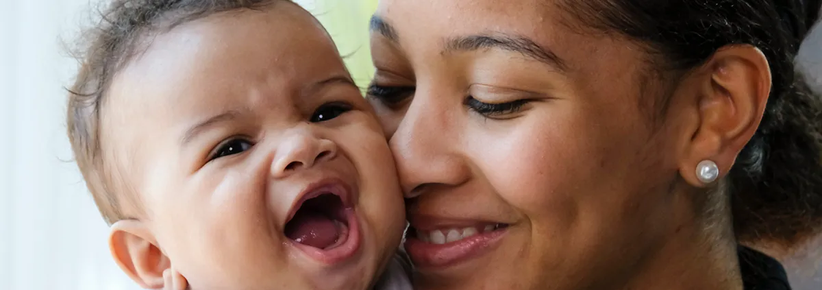 Mom cuddling smiling baby