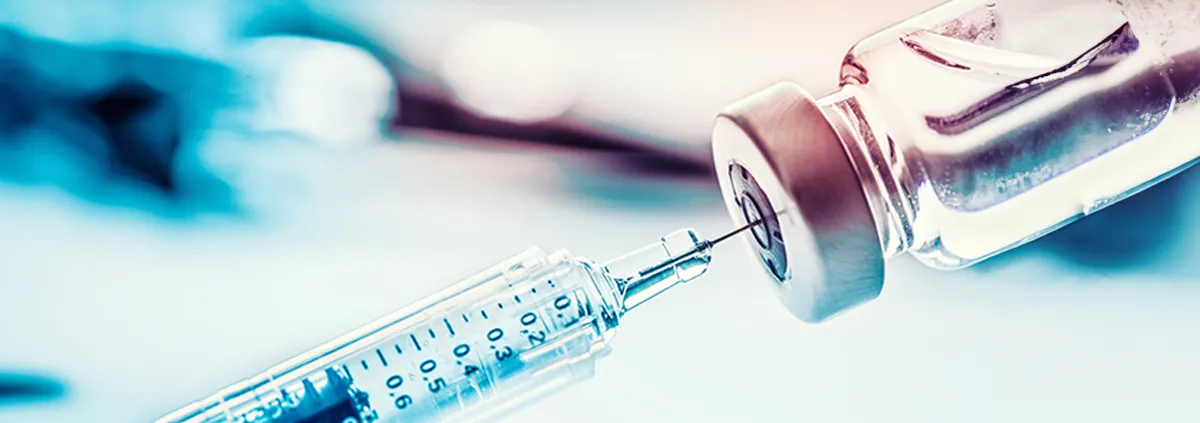 Close up image of a vaccine vial and a syringe