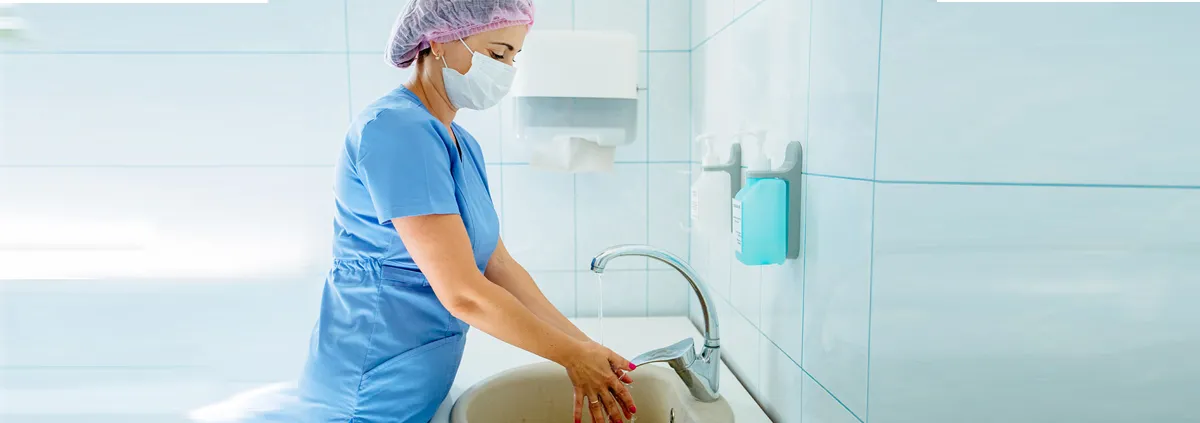 Medical professional washing her hands at the sink