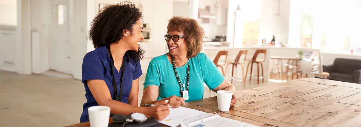 Medical professional smiling at senior woman in healthcare facility