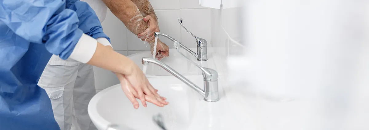 Two medical professionals washing hands at the sink