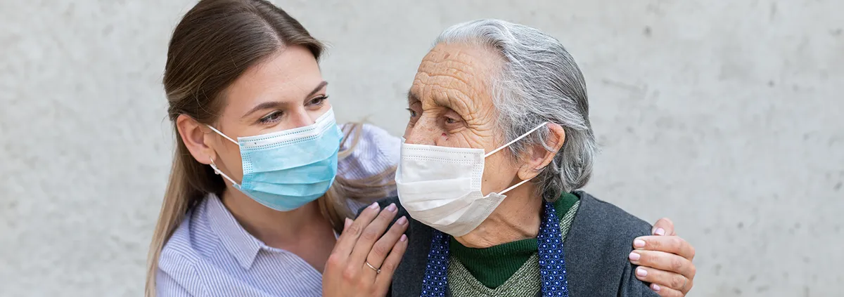 A medical professional holding the shoulders of a senior man