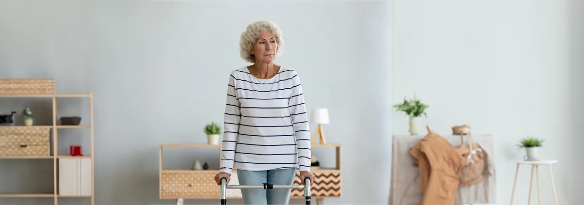 Senior woman in nursing home walking with a walker