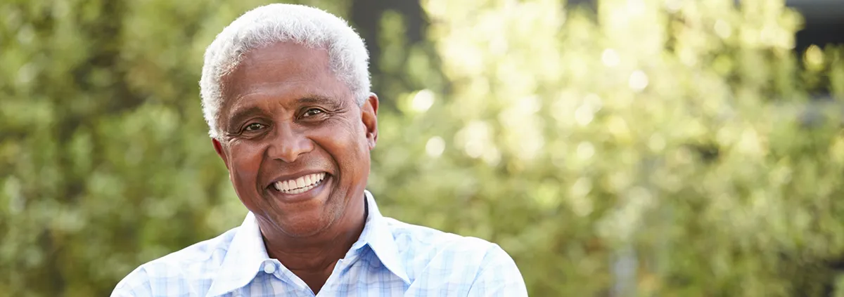 Older African American male smiling in front of camera 