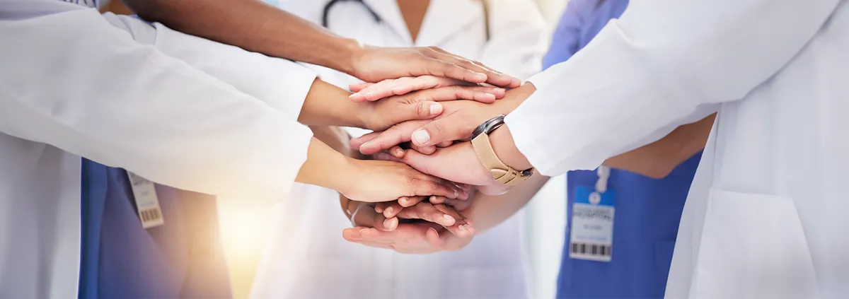 Image of clinicians hands in a huddle