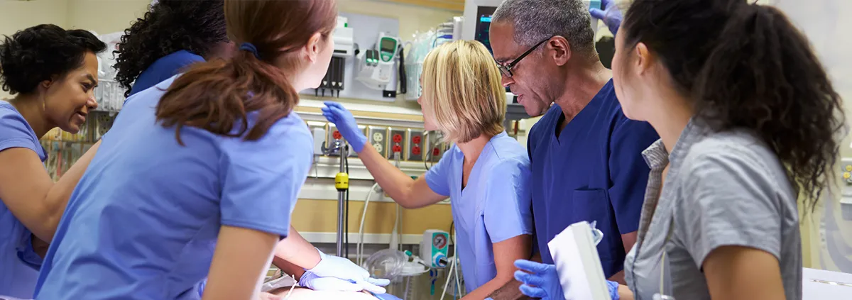 Clinicians surrounding patient on hospital bed