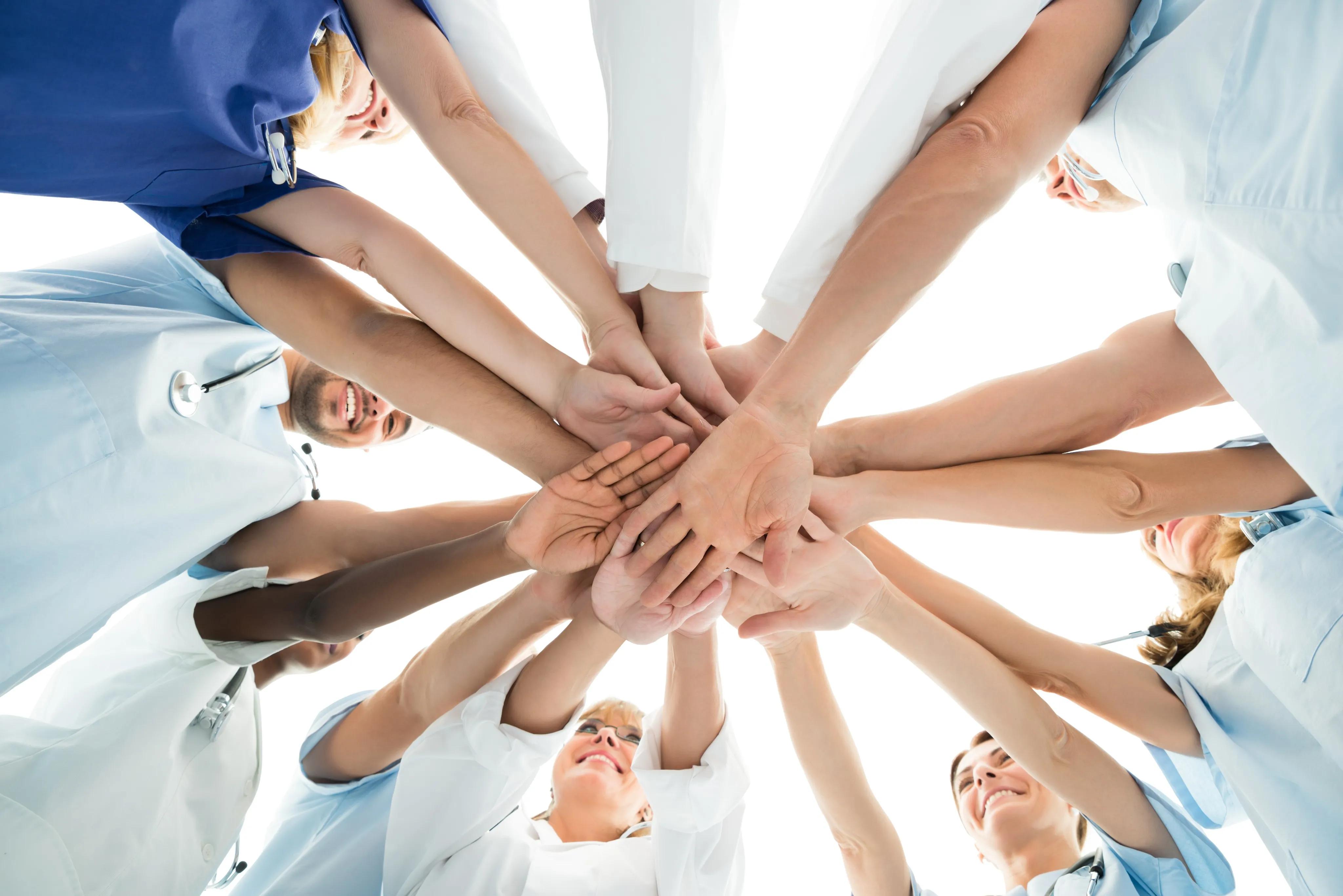 Directly below shot of multiethnic medical team stacking hands over white background