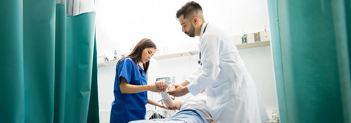 Doctor and nurse assessing a patient laying in hospital bed