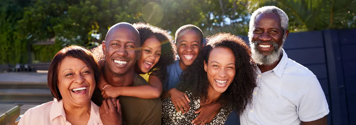 A three generational group family photo with two women, two men, and a young boy and girl