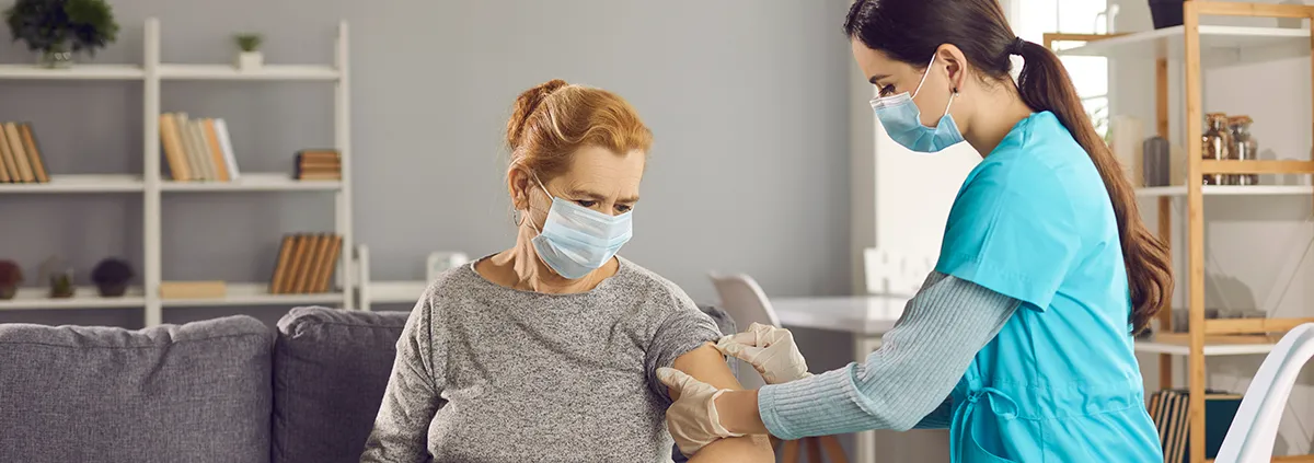 Clinician giving patient a vaccine in a nursing home setting